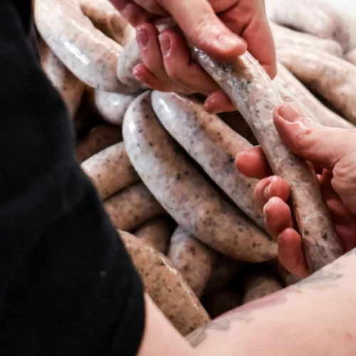 Hands holding linked sausages